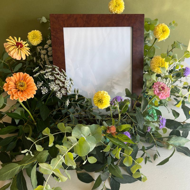 Flowers arranged around a framed photograph for a celebration of life